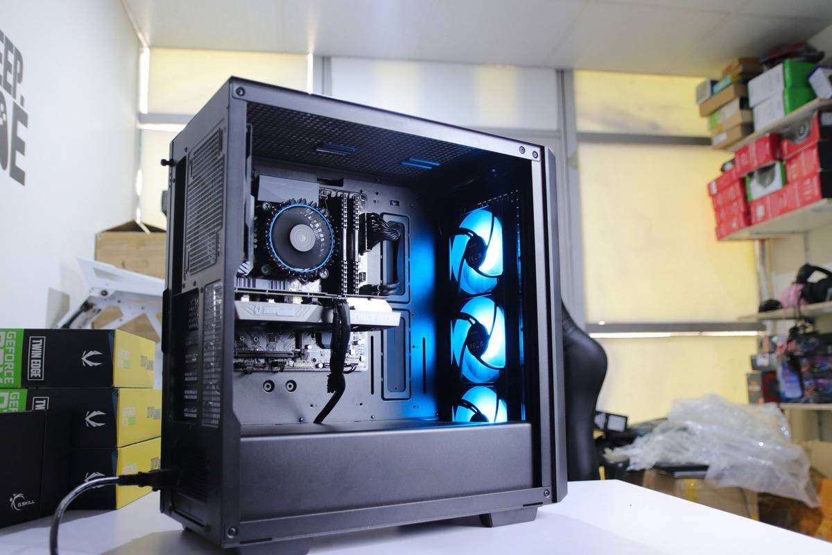 Diagram showing ideal 3-fan airflow in a gaming PC: two front intakes (blue arrows) pulling cool air, one rear exhaust (red arrow) expelling hot air over GPU and CPU